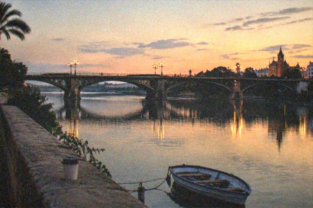 The Triana bridge crossing the Guadalquivir River at dusk