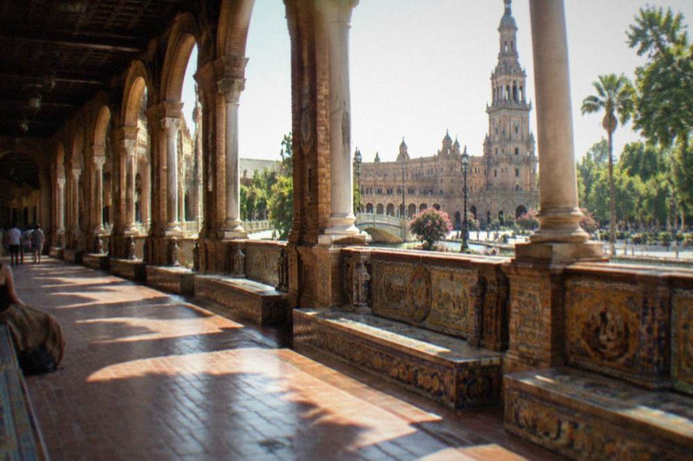 Open walkway and tiled benches along the Plaza de España arcade