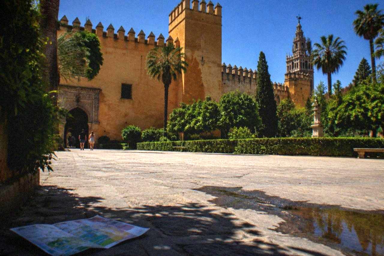 The walled facade and towers of the Real Alcázar palace in daylight