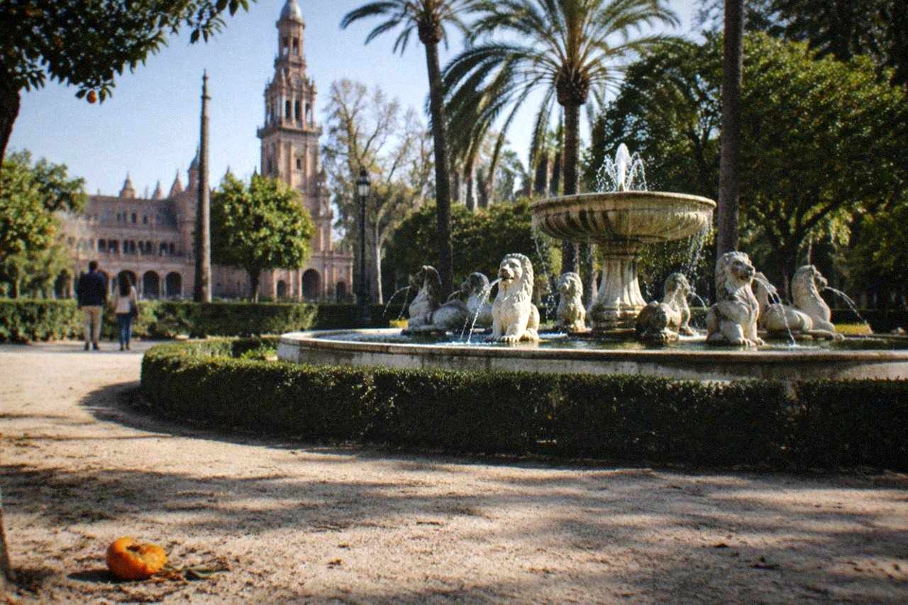 Open plaza in central Seville with tiled benches and a fountain under a clear sky