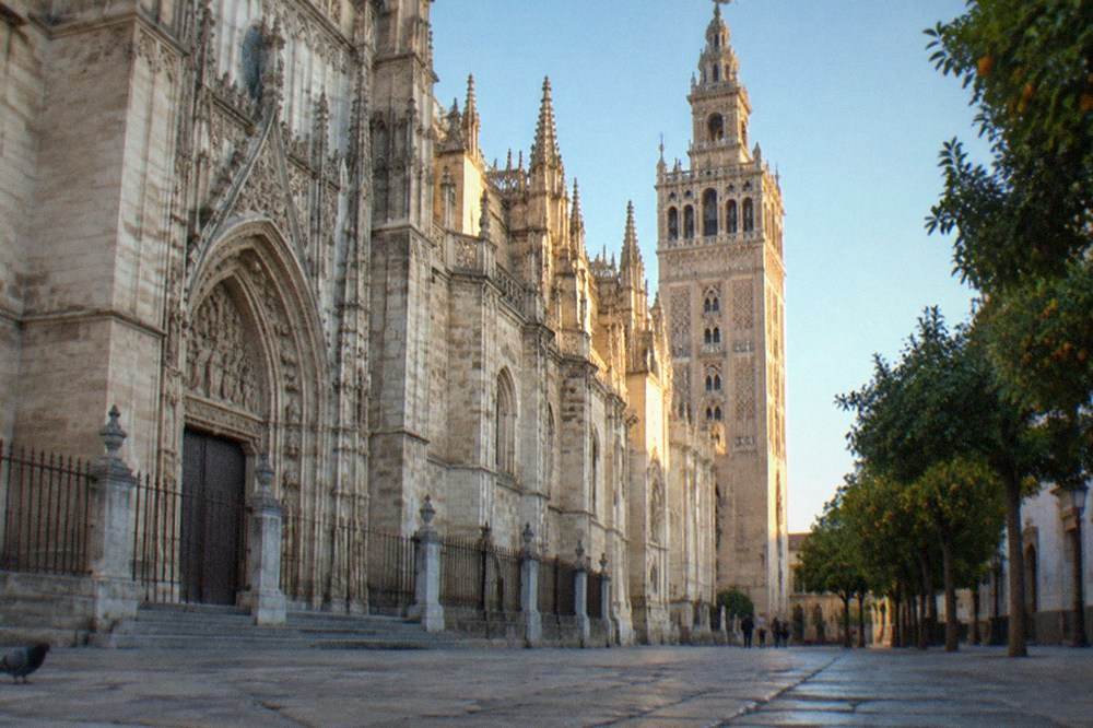 Seville Cathedral facade and the Giralda tower against a clear sky