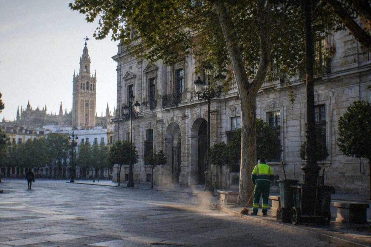 Wide open square in central Seville with historic facades and empty walkways in morning light