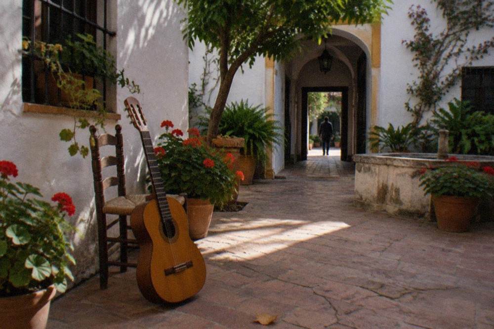 Flamenco guitar leaning against a chair in an empty courtyard