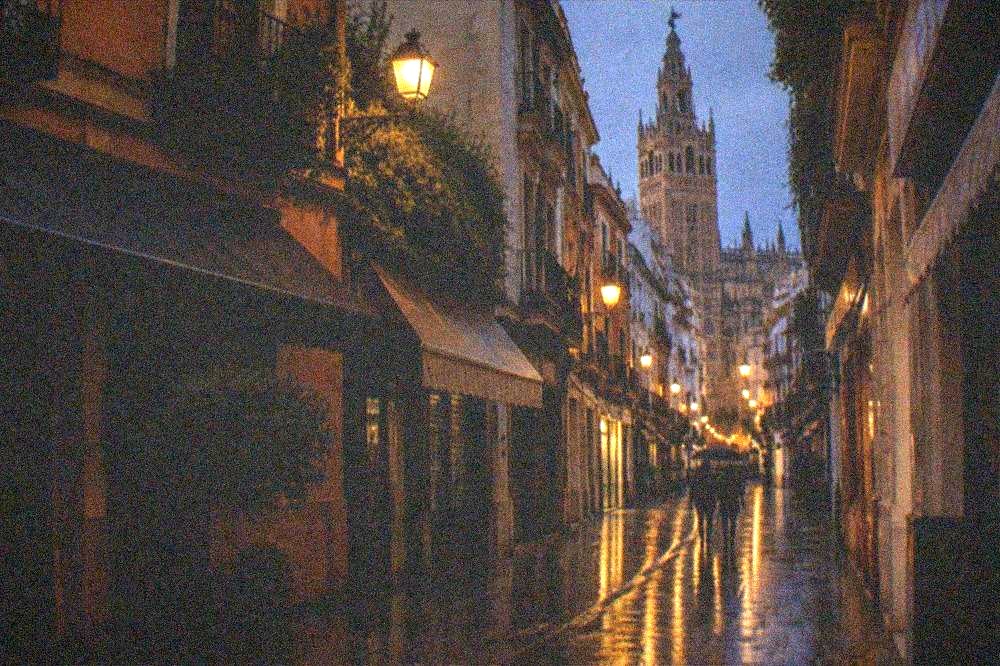 An evening street in a historic city centre with lamps on stone buildings