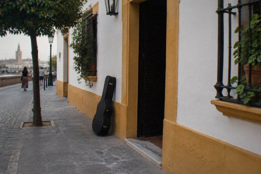 Empty flamenco stage with wooden chairs and a guitar in a Seville courtyard