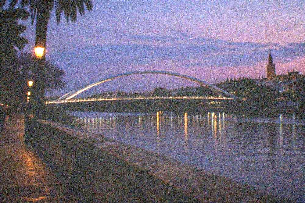 Riverside promenade and bridge over the Guadalquivir at dusk in Seville