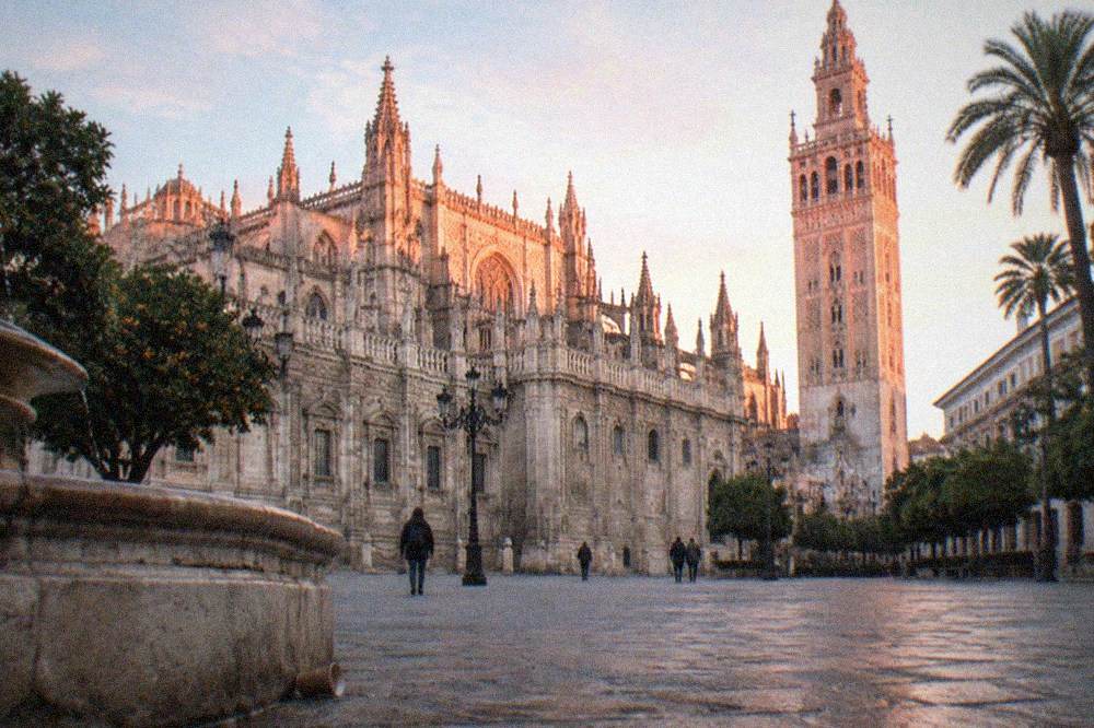 Seville Cathedral facade and the Giralda tower seen from a square