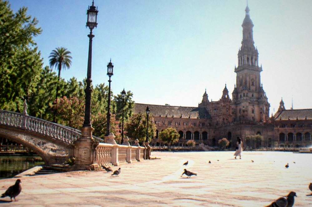 The open plaza of Plaza de España with its tower and arcade in daylight