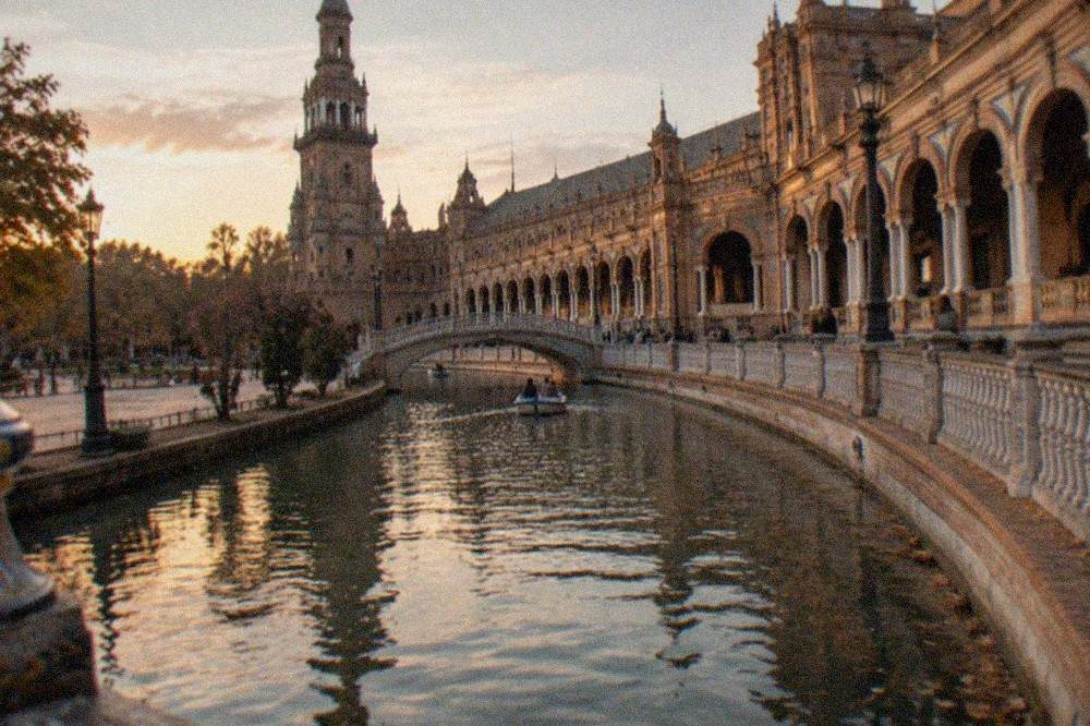 Arcada semicircular y canal de la Plaza de España iluminados por la luz del atardecer
