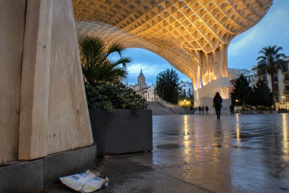 Estructura de celosía de madera del Metropol Parasol vista desde la plaza gratuita que hay debajo al anochecer