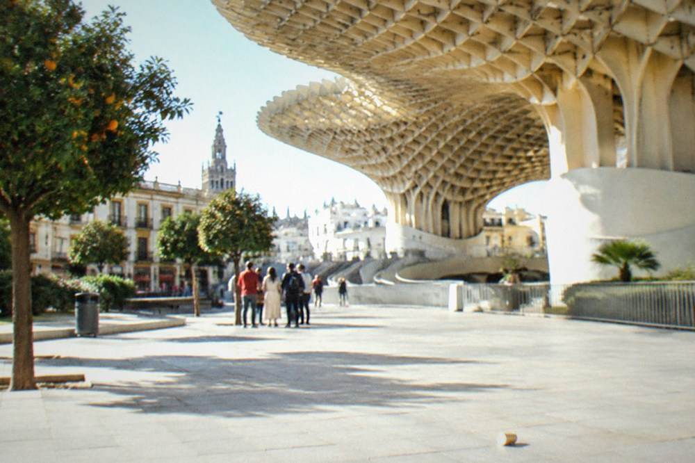 A walking tour group gathered in a sunlit square in central Seville